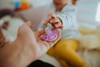 Tangan Terpotong Memberi Pacifier Kepada Bayi Perempuan