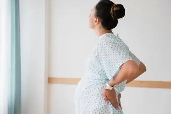 Беременная женщина на ранних сроках родов стоя