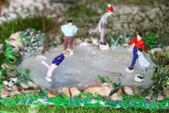 Gente en miniatura patinando en un estanque congelado casero