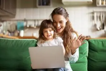 Feliz madre y niña agitando las manos haciendo videollamadas