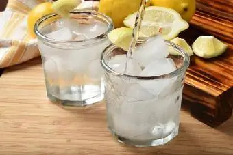 Лимон тілімдері бар стақанға газдалған су құйыңыз