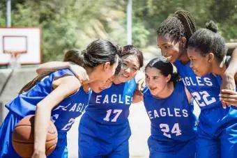 Jugadoras de baloncesto acurrucadas en la cancha