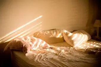 Luz solar na cama bagunçada em casa