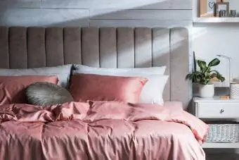 Cama com lindos lençóis de seda no interior elegante do quarto