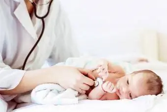 Vrouwelijke arts onderzoekt baby met stethoscoop