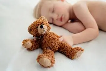 Malý chlapec spí s plyšovým medvedíkom