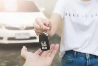 vrouw geeft de autosleutel