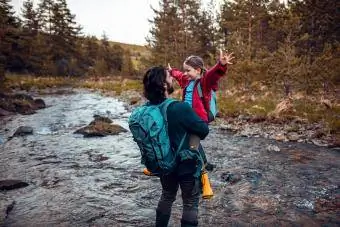 Padre e figlia attraversano un ruscello