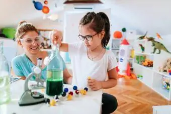 Niña y su madre haciendo experimento científico.