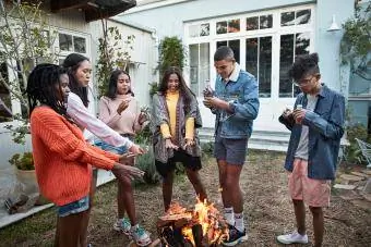 Vriende warm hande oor vreugdevuur