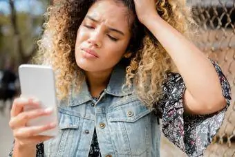 Femeie nefericită de rasă mixtă trimite mesaje pe telefonul mobil