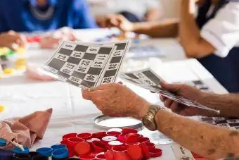 Bingo oyunu için kıdemli adamın elleri sayı kartlarını dağıtıyor