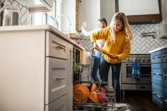 Tween flickor som diskar i modernt kök