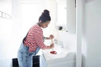 Žena otčepljuje umivaonik klipom u kupaonici