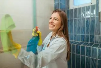 युवा महिला बाथरूम साफ कर रही है
