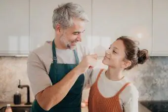 Девочка-подросток со своим отцом вместе на кухне