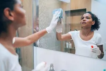 Frau putzt Badezimmerspiegel