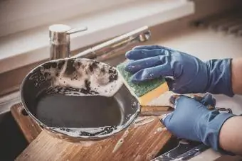 le mani lavano i piatti con detersivi