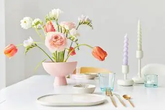 ფერადი გაზაფხულის თაიგული და სანთლები მაგიდაზე