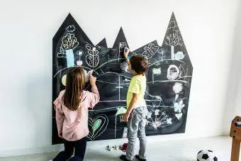 Fëmijët vizatojnë në dërrasën e zezë