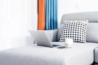 الكمبيوتر المحمول وفنجان القهوة على الأريكة
