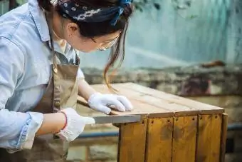 Vrouw die hout vormgeeft met rasp