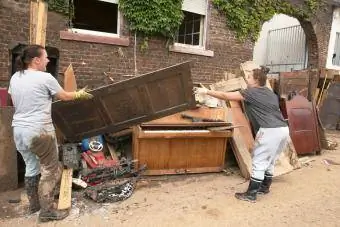 Empleados de un taller de restauración de muebles antiguos tiran una puerta a un montón