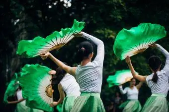 Bailarines chinos con abanicos verdes.