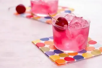 Červený mocktail s třešničkou na barevném ubrousku