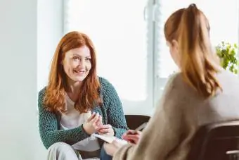 Mujer sonriente con terapeuta en el centro comunitario