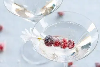 Šventinės raudonos spanguolės puošia martinio taurę putojančiais burbuliukais