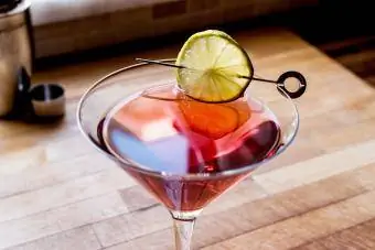 Mocktail Cosmopolitan dengan pengocok di permukaan kayu