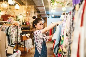 Młoda kobieta robi zakupy w sklepie z odzieżą vintage