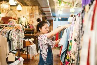 Wanita muda berbelanja di toko pakaian vintage