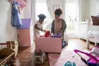 Mère et fille ramassant des jouets dans un conteneur