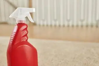 Sprayflaska med väteperoxid på beige matta