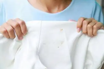 žena drži košulju sa mrljom od rđe