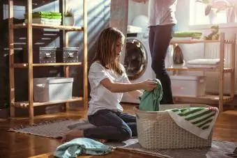 Datter hjælper mor med at organisere vaskerummet