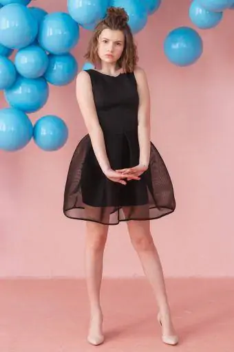 Siyah kokteyl elbisesi giyen genç kız