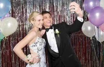 Adolescente e menina tirando uma foto no baile