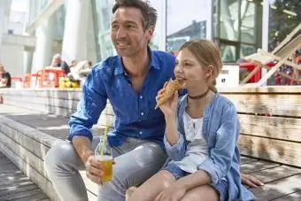 Açık havadaki bir kafede içkili baba ve dondurma külahlı kızı