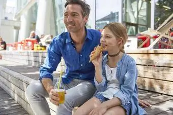 Padre con drink e figlia con cono gelato in un bar all'aperto