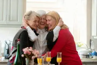 Yaşlı kadın iki kızına sarılıyor