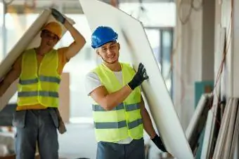 dos hombres levantando paneles de yeso