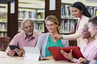 Couple de personnes âgées apprenant à utiliser des appareils avec un bibliothécaire