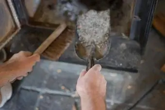 Një burrë pastron hirin nga një oxhak