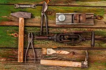 Antike Werkzeuge auf verwittertem Holztisch