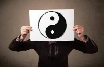 Biznesmeni që mban një letër me yin-yang