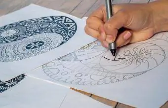 Naisen käsi piirtää yin yang
