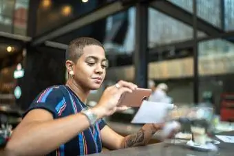 Mujer joven depositando cheque por teléfono